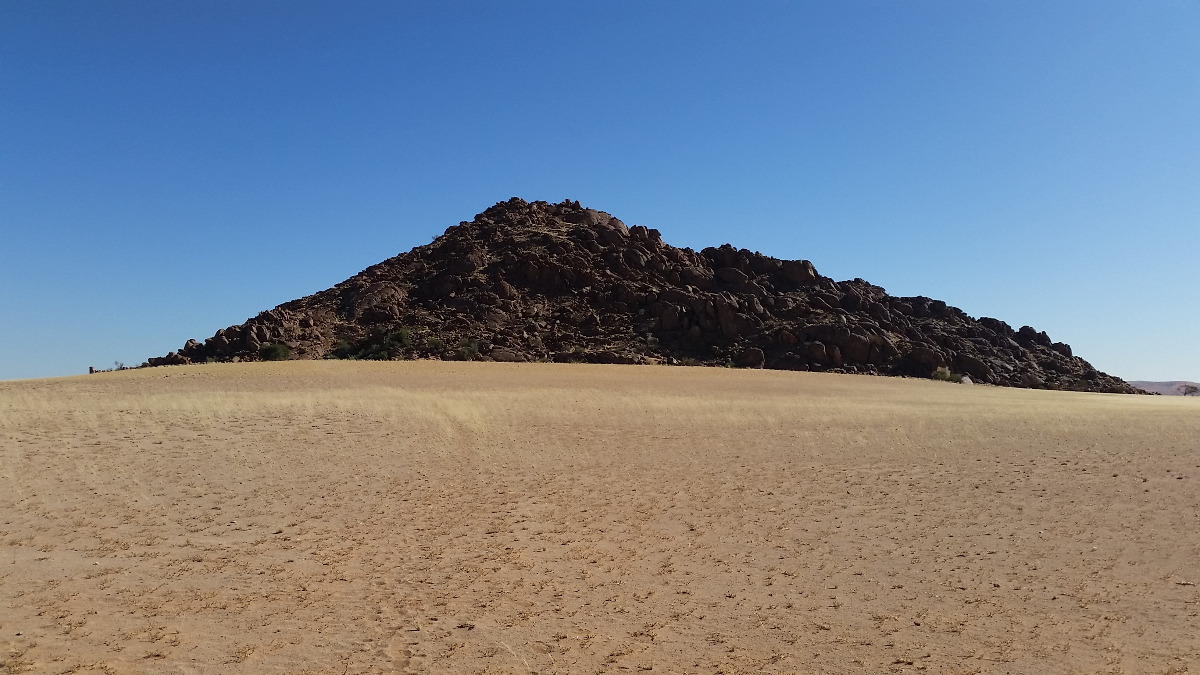 Namibia: Granitberg hinter „Desert Camp“ an der D826